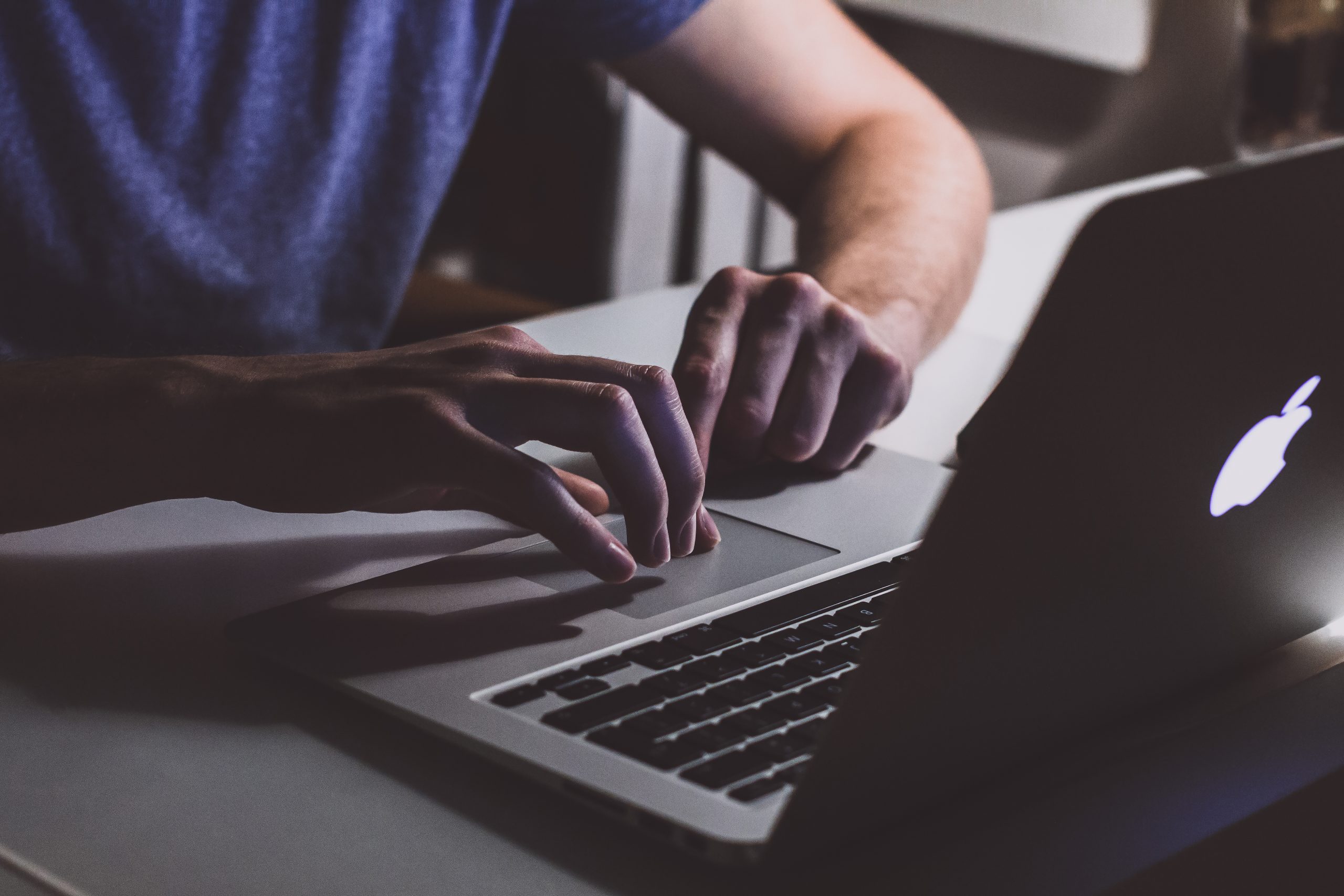 Person touching open macbook on table